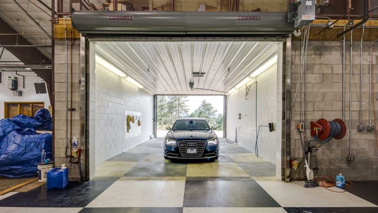Audi sedan sitting in a custom built car wash with checkered floor.